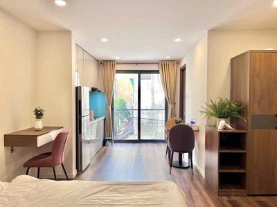 The balcony studio apartment is full of furniture away from the kitchen at the center of District 7