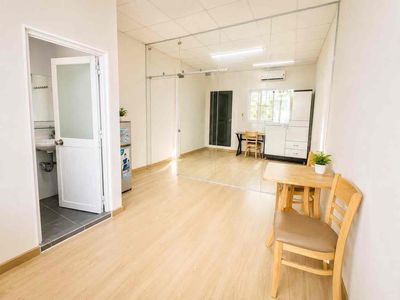 A kitchen bedroom with a window full of furniture near the green row.
