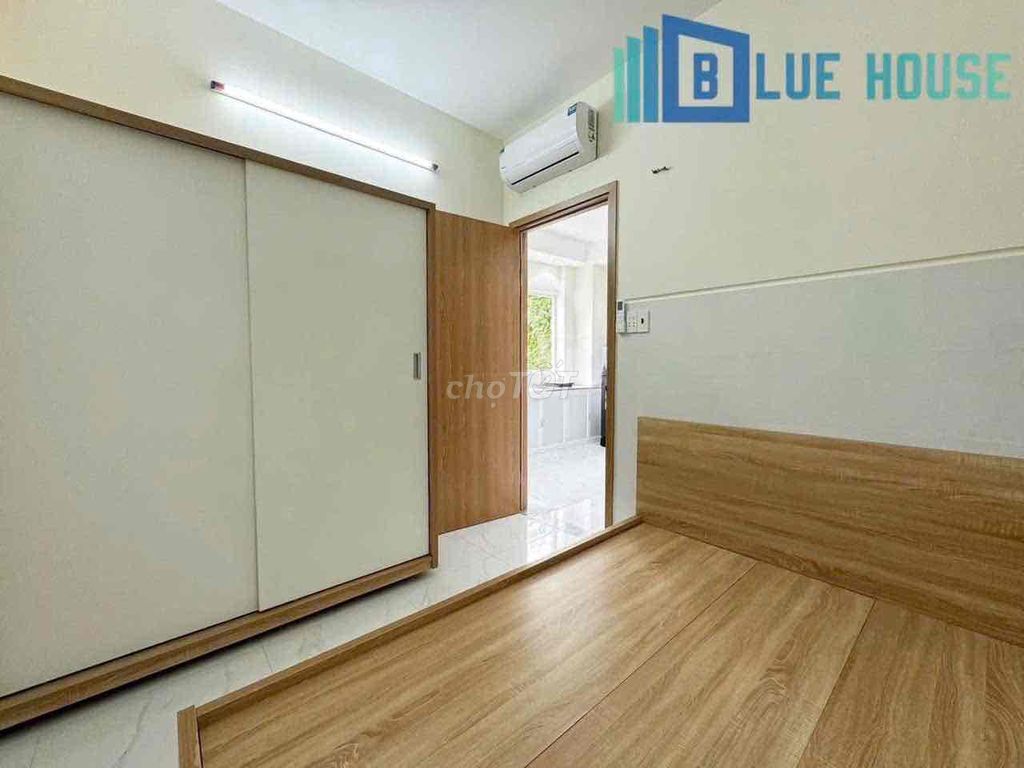 Two brand-new apartment bedrooms in a full-house bathroom with windows on it.
