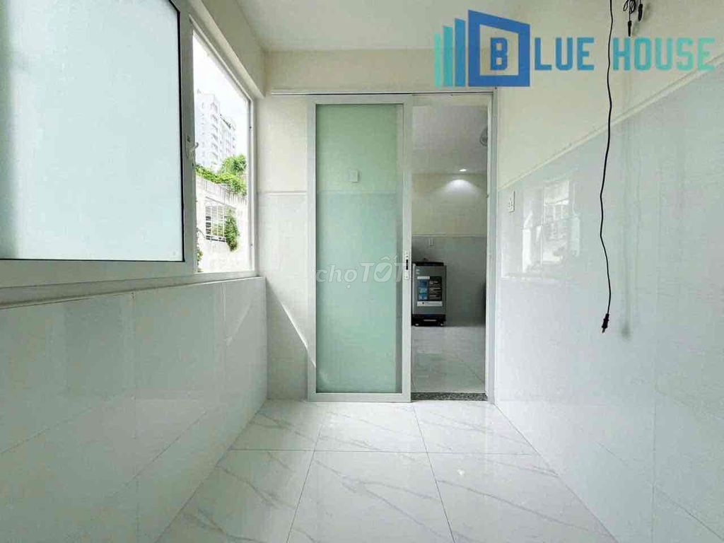 Two brand-new apartment bedrooms in a full-house bathroom with windows on it.
