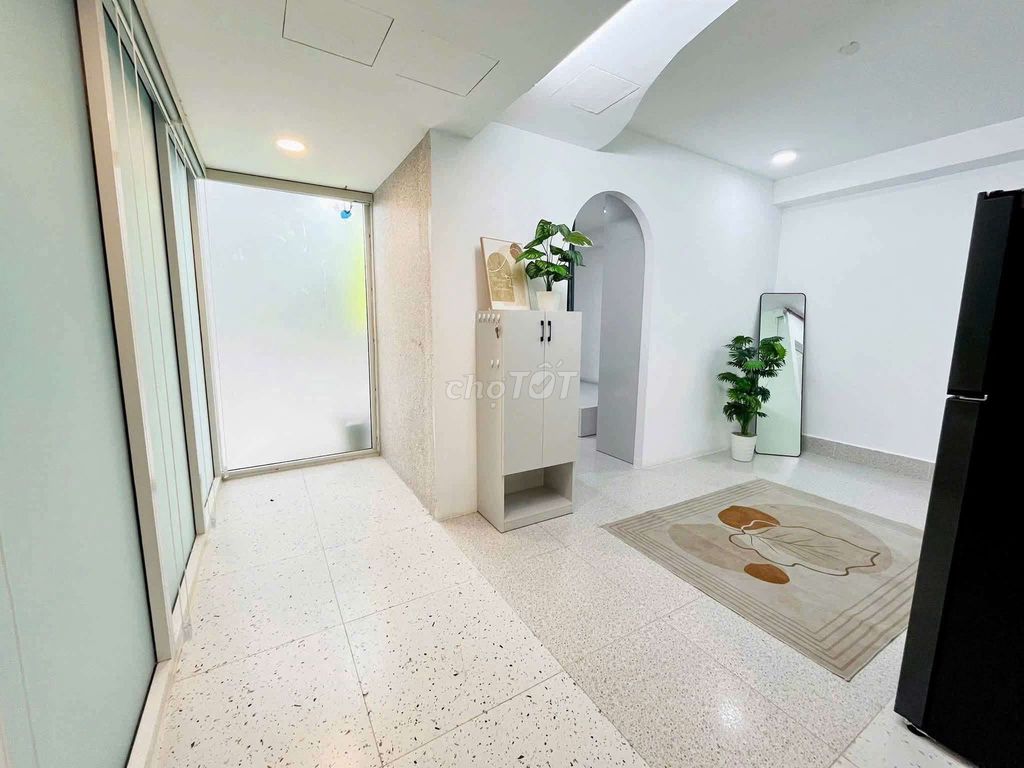 The apartment is full of furniture. The front door is right on the Tries.