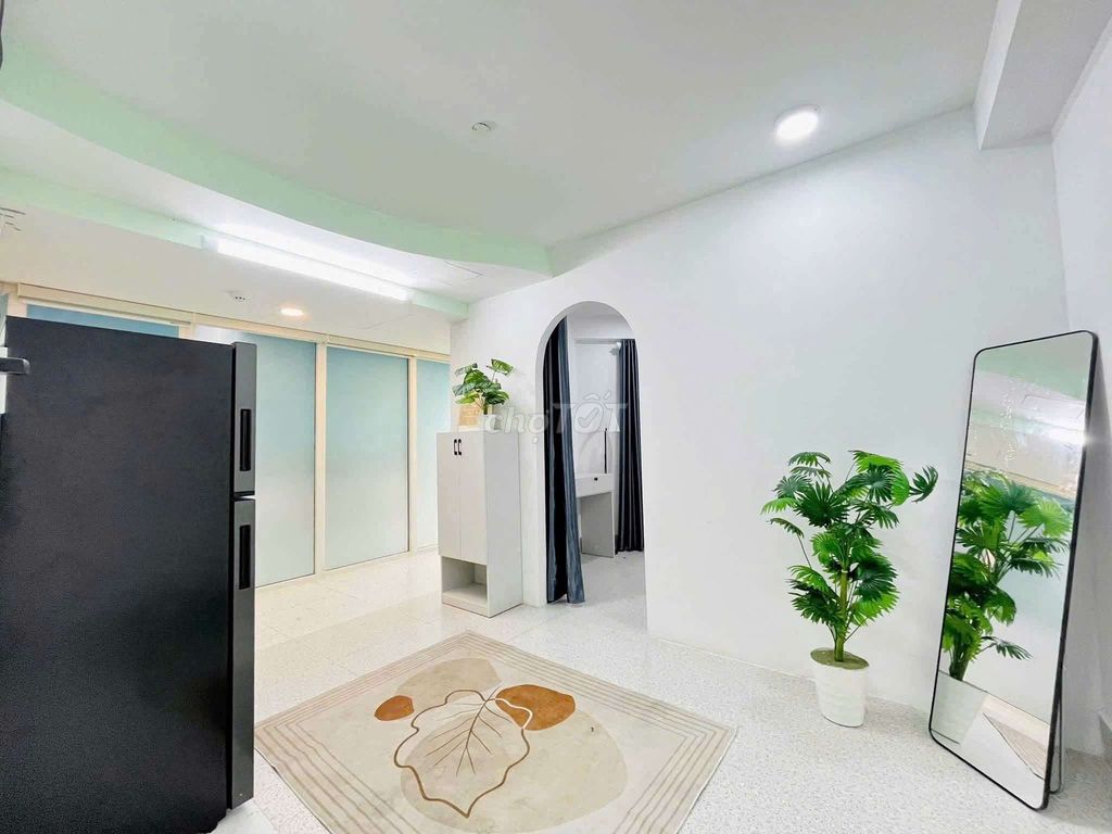 The apartment is full of furniture. The front door is right on the Tries.