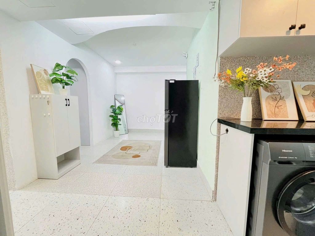 The apartment is full of furniture. The front door is right on the Tries.