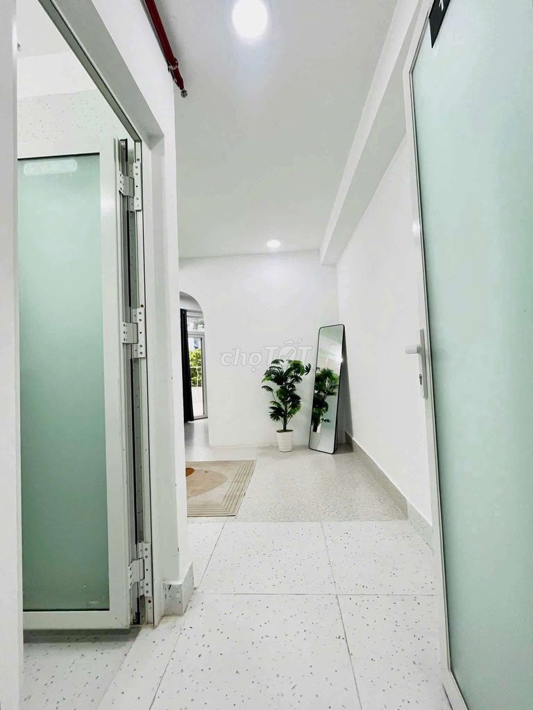 The apartment is full of furniture. The front door is right on the Tries.