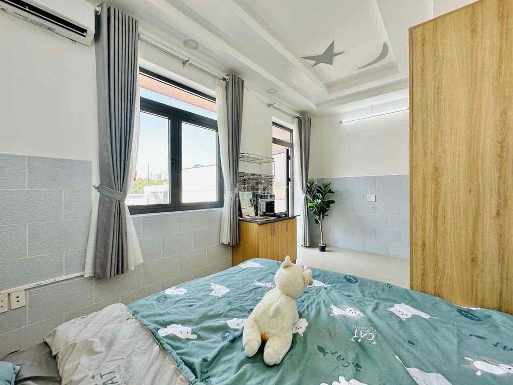 A studio with a balcony and a large window